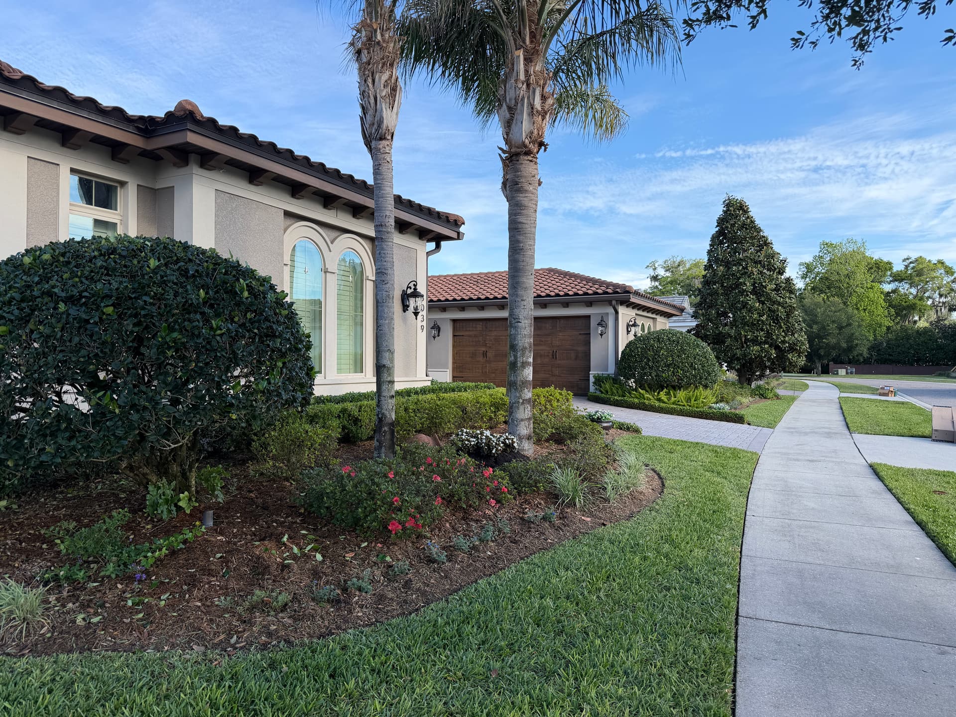 Mediterranean estate with mature palms and brick paver driveway in Winter Park, FL