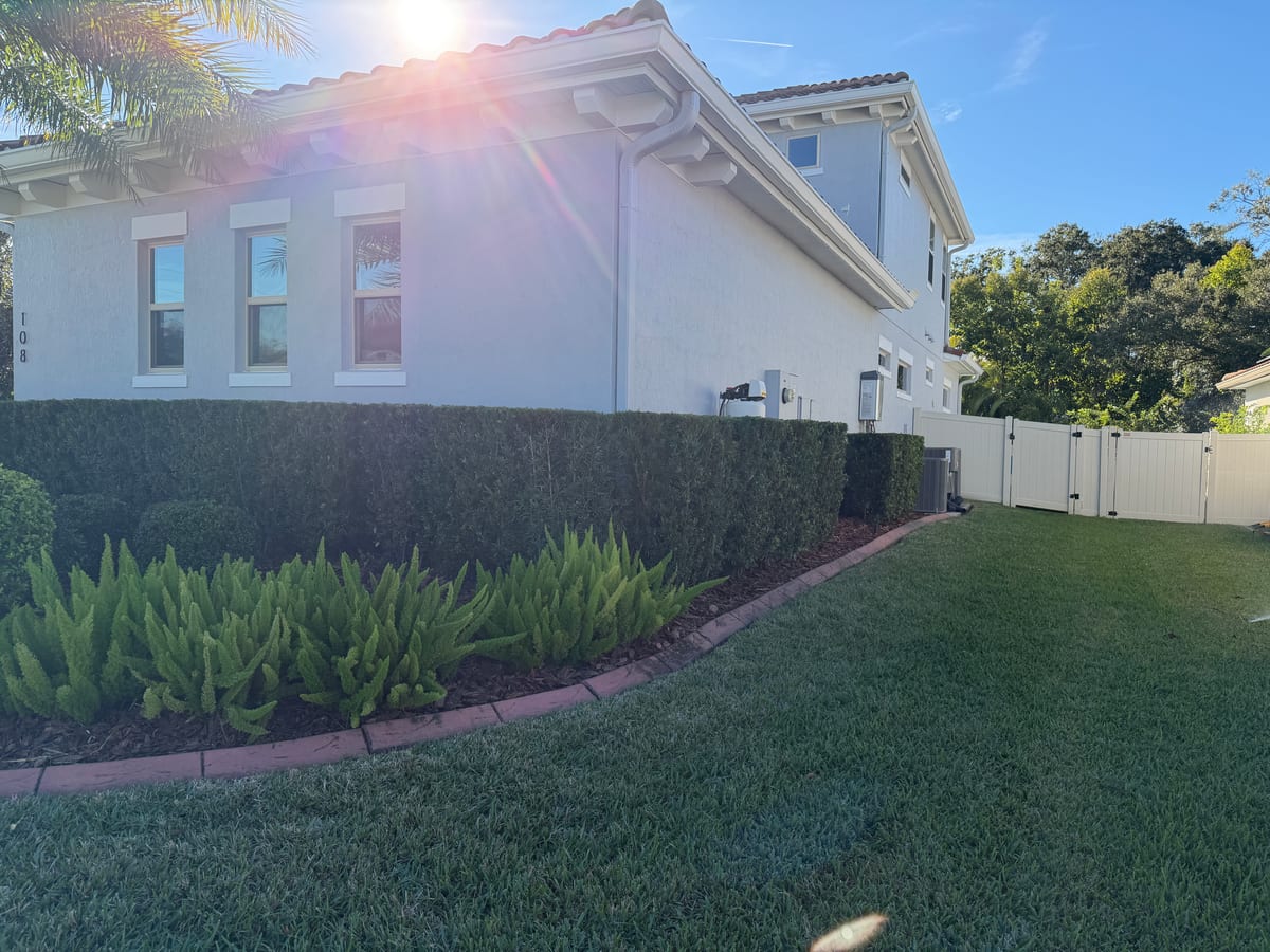 Trimmed hedge row and freshly maintained turf at a Florida residential property